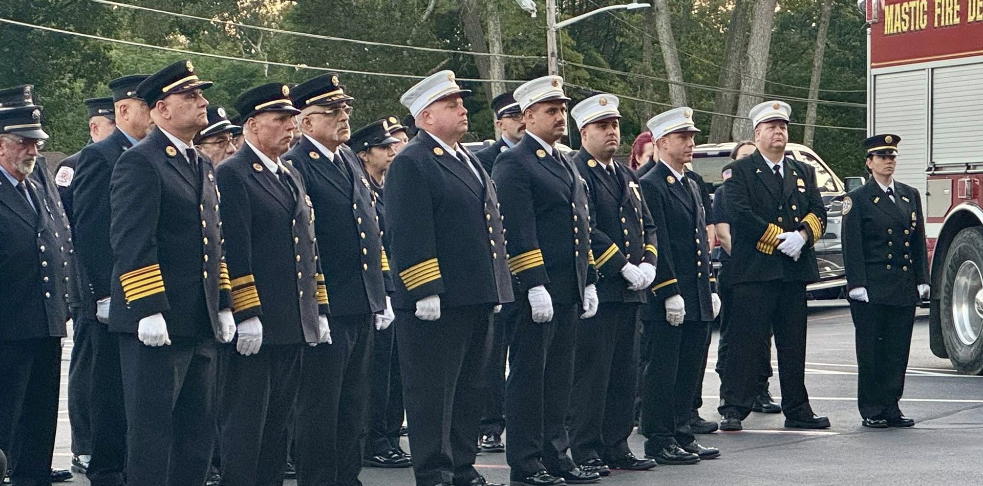 A line of Fire Department Personnel standing at attention in dress uniform