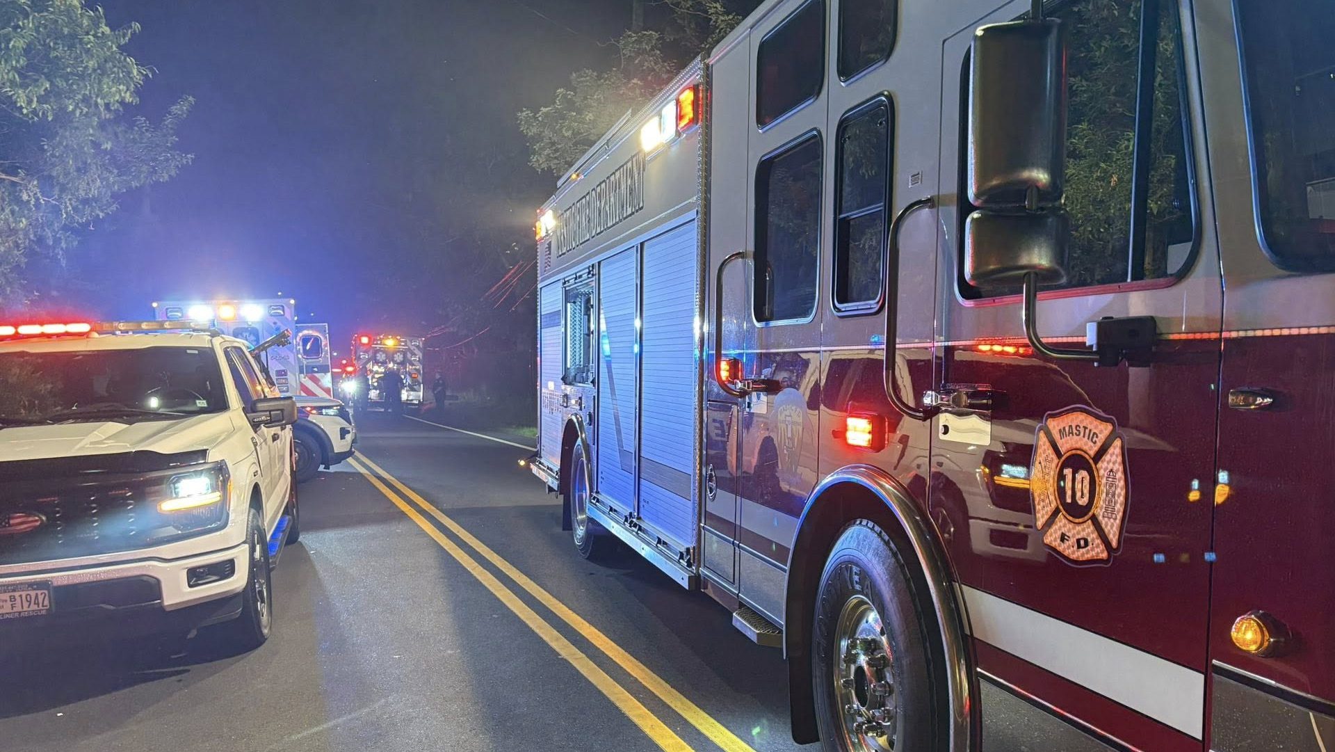 Fire department vehicles parked on a neighborhood street at night, responding to an emergency